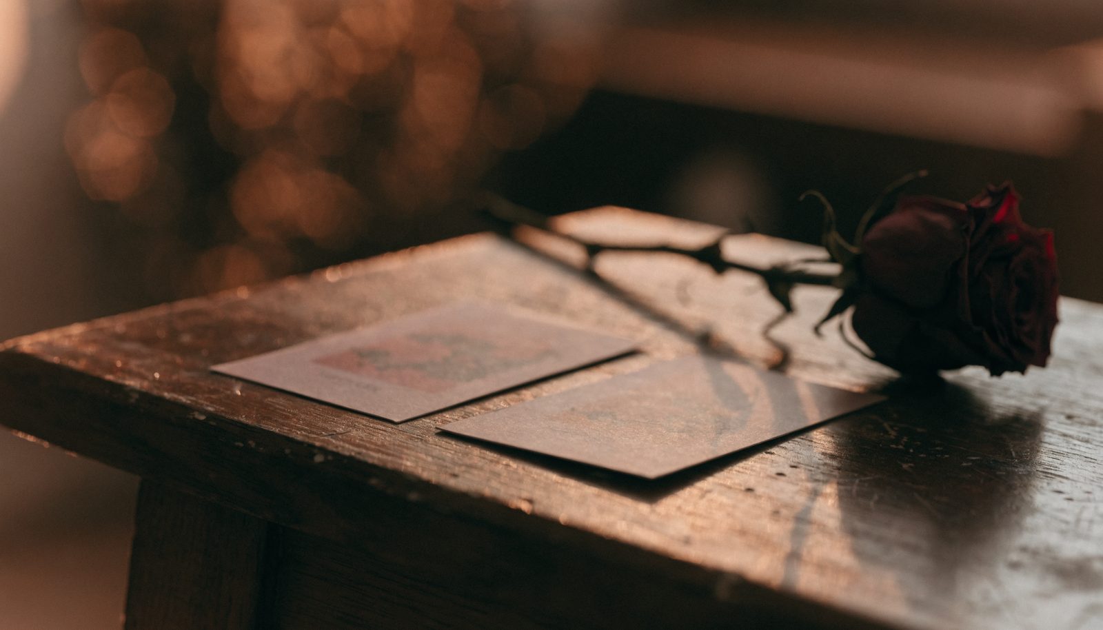Deux cartes de tarot posées côte à côte près d'une rose séchée, une consultation de voyance sur une question d'amour